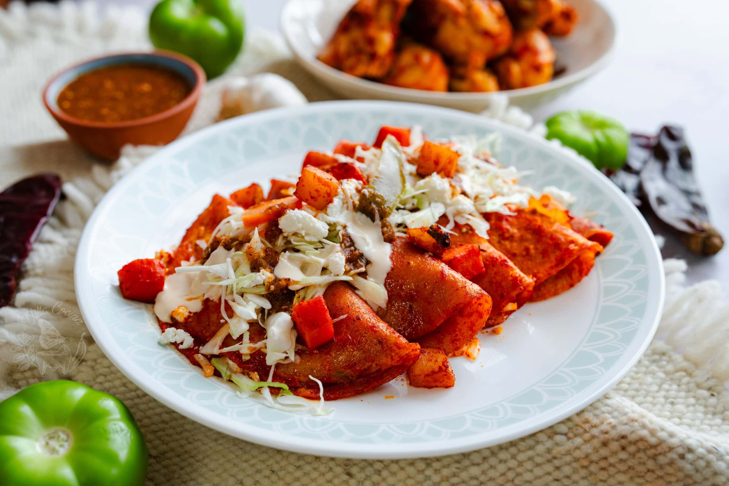Plated enchiladas rojas with crema and queso fresco